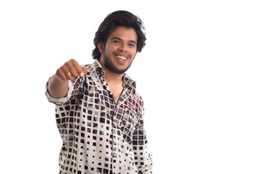 Beyaz arka planda poz veren genç bir adam.