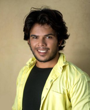 Yakışıklı moda genç adam dışarıda poz veriyor.