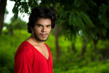 Yakışıklı moda genç adam dışarıda poz veriyor.