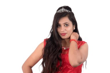 Kırmızı elbiseli genç kız beyaz arka planda poz veriyor.