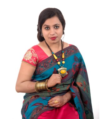 Güzel genç kız beyaz arka planda geleneksel Hint sarisi pozu veriyor..