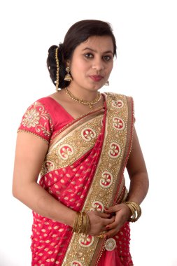 Güzel genç kız beyaz arka planda geleneksel Hint sarisi pozu veriyor..