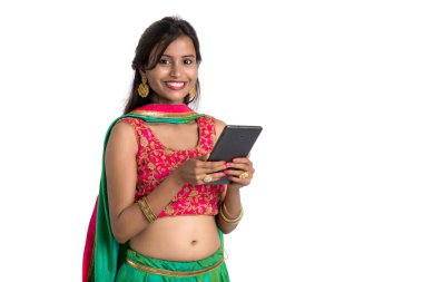 Genç Hintli geleneksel kız beyaz arka planda izole edilmiş cep telefonu ya da akıllı telefon kullanıyor.