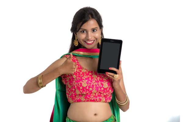 若いインドの伝統的な女の子は 携帯電話やスマートフォンを使用して 白い背景に空白の画面のスマートフォンを示しています — ストック写真