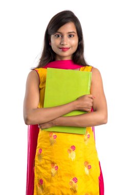 Elinde kitapla beyaz arka planda poz veren güzel bir genç kız.