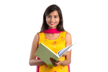 Elinde kitapla beyaz arka planda poz veren güzel bir genç kız.