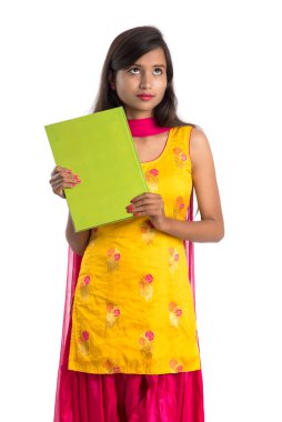 Elinde kitapla beyaz arka planda poz veren güzel bir genç kız.