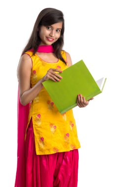 Elinde kitapla beyaz arka planda poz veren güzel bir genç kız.