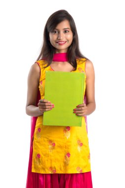 Elinde kitapla beyaz arka planda poz veren güzel bir genç kız.