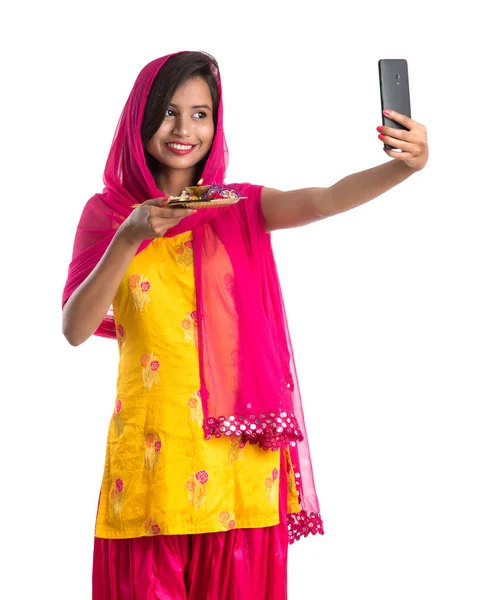 美しいです若いです幸せな女の子取ります自殺とともにPoja Thali使用して携帯電話やスマートフォン上の白い背景 — ストック写真