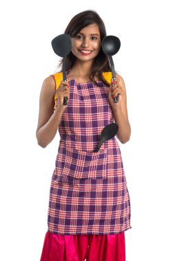 Genç Hintli kadın mutfak aletlerini tutuyor (kaşık, stapula, kepçe, ve tava, vb.) beyaz arkaplanda