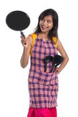 Genç Hintli kadın mutfak aletlerini tutuyor (kaşık, stapula, kepçe, ve tava, vb.) beyaz arkaplanda