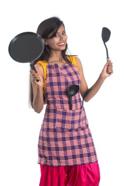 Genç Hintli kadın mutfak aletlerini tutuyor (kaşık, stapula, kepçe, ve tava, vb.) beyaz arkaplanda