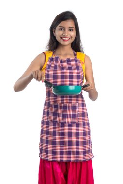 Genç Hintli kadın mutfak aletlerini tutuyor (kaşık, stapula, kepçe, ve tava, vb.) beyaz arkaplanda