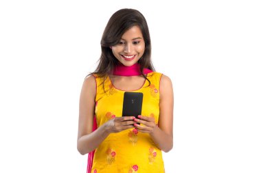 Beyaz arka planda izole edilmiş cep telefonu ya da akıllı telefon kullanan genç bir Hintli kız.