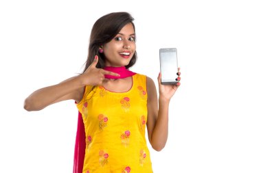 Beyaz arka planda boş ekran akıllı telefonu, cep telefonu ya da tablet telefonu tutan ve gösteren güzel bir kadın..