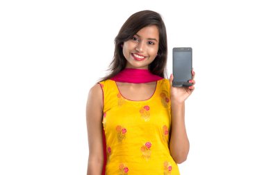 Beyaz arka planda boş ekran akıllı telefonu, cep telefonu ya da tablet telefonu tutan ve gösteren güzel bir kadın..