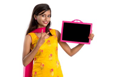 Tahtada ya da tahtada beyaz arka planda izole edilmiş bir şey tutan ve gösteren güzel bir genç kız.