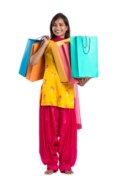 美しいインドの若い女の子を保持し 白い背景にショッピングバッグでポーズ — ストック写真