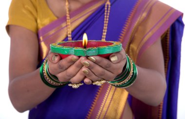 Beyaz arka planda ışık festivali sırasında elinde diya, Diwali ya da kadın eli fener tutan bir kadının portresi.
