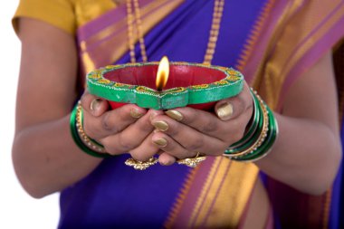 Beyaz arka planda ışık festivali sırasında elinde diya, Diwali ya da kadın eli fener tutan bir kadının portresi.