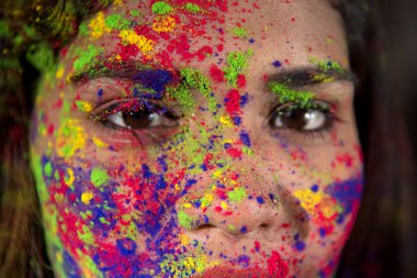Holi renk festivali vesilesiyle renkli yüzlü mutlu bir genç kızın portresi..
