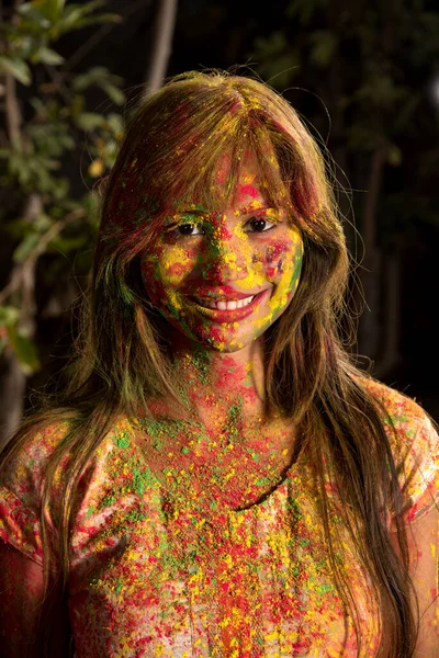Portrait of a happy young girl on the festival of colors Holi. Girl posing and celebrating the festival of colors.
