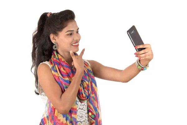 白い背景に隔離された携帯電話やスマートフォンを使用して若いインドの女の子 — ストック写真
