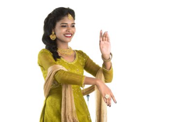 Gülümseyen neşeli kız beyaz arka planda izole edilmiş işaret gösteriyor.