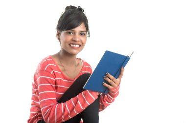 Elinde kitapla beyaz arka planda poz veren güzel bir genç kız.