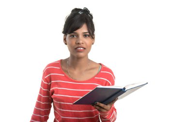 Elinde kitapla beyaz arka planda poz veren güzel bir genç kız.