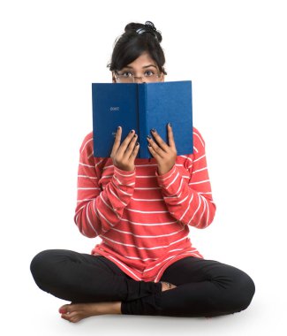 Elinde kitapla beyaz arka planda poz veren güzel bir genç kız.