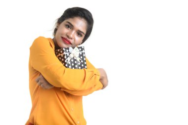 Beyaz bir arka planda hediye kutuları tutan mutlu Hintli genç kızın portresi..