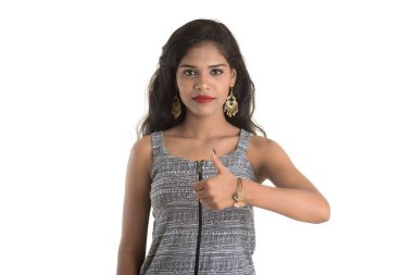 Gülümseyen neşeli kız beyaz arka planda izole edilmiş işaret gösteriyor.