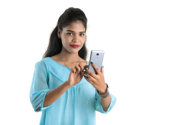 白い背景に隔離された携帯電話やスマートフォンを使用して若いインドの女の子 — ストック写真