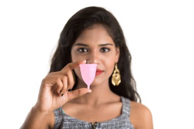 Genç kız ellerinin regl bardağını tutması, jinekoloji konsepti, regl bardağının kullanımını onaylayan baş parmaklar.