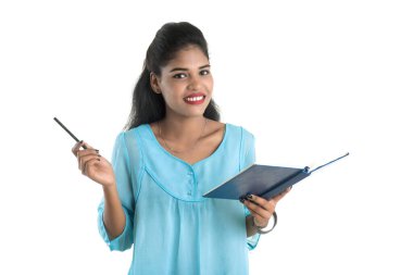 Elinde kitapla beyaz arka planda poz veren güzel bir genç kız.