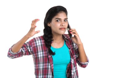 Beyaz arka planda izole edilmiş cep telefonu ya da akıllı telefon kullanan genç bir Hintli kız.