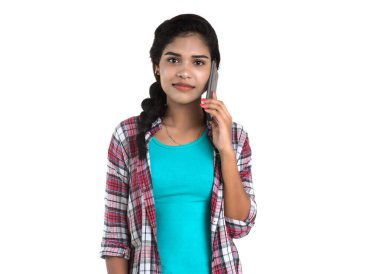 Beyaz arka planda izole edilmiş cep telefonu ya da akıllı telefon kullanan genç bir Hintli kız.