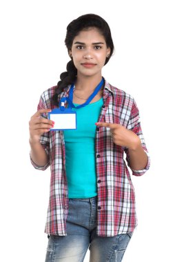 Genç bir kadın, elinde kimliği olmayan beyaz bir plastik kimlik tutuyor..