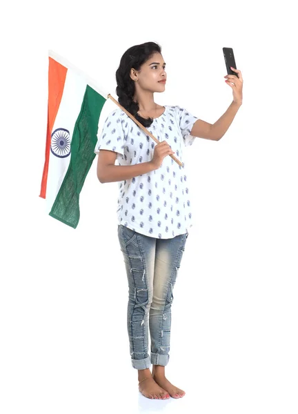 在印第安人独立日 印第安人共和国日 白人背景下使用带有印度国旗或三色旗的手机的女孩 — 图库照片