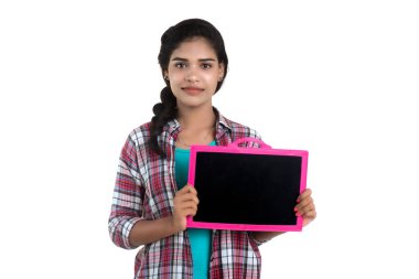 Beyaz bir arka planda tahtayla poz veren güzel bir genç kız.