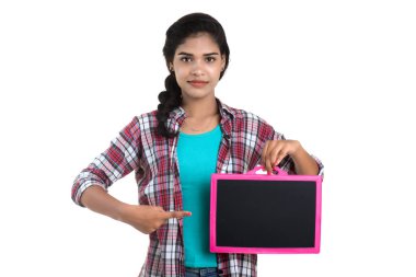 Beyaz bir arka planda tahtayla poz veren güzel bir genç kız.