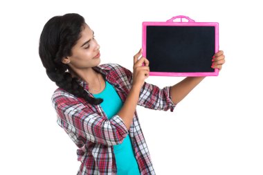 Beyaz bir arka planda tahtayla poz veren güzel bir genç kız.