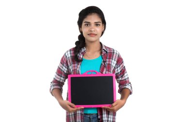 Beyaz bir arka planda tahtayla poz veren güzel bir genç kız.