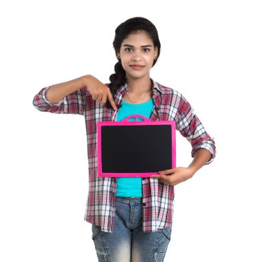 Beyaz bir arka planda tahtayla poz veren güzel bir genç kız.