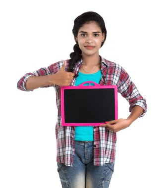 Beyaz bir arka planda tahtayla poz veren güzel bir genç kız.