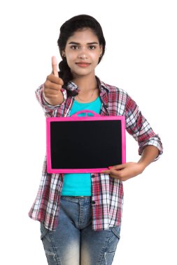 Beyaz bir arka planda tahtayla poz veren güzel bir genç kız.