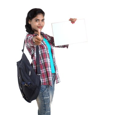 Sırt çantalı genç Hintli kadın beyaz bir zeminde duran ve beyaz tahta tutan,.