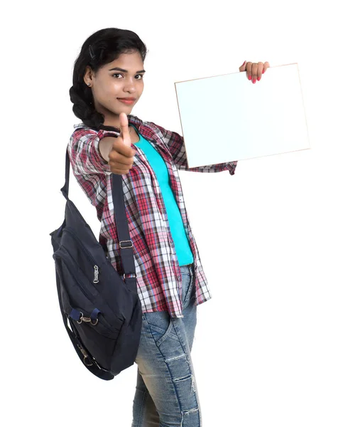 Sırt çantalı genç Hintli kadın beyaz bir zeminde duran ve beyaz tahta tutan,.